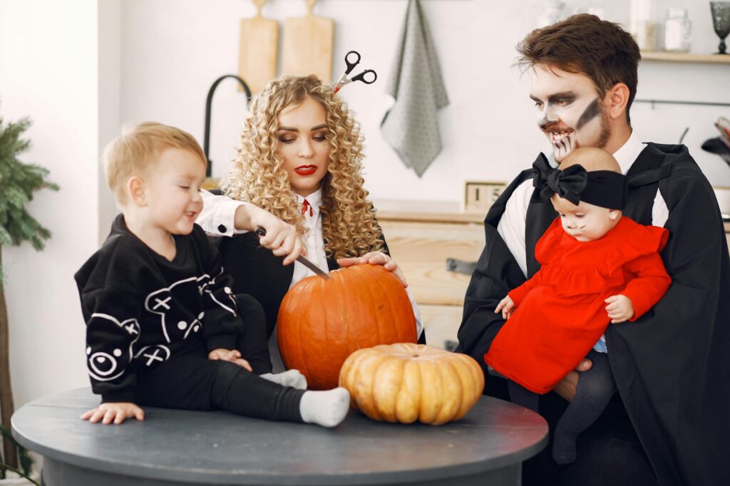 Famille en costumes d'Halloween avec citrouilles autour d'une table festive