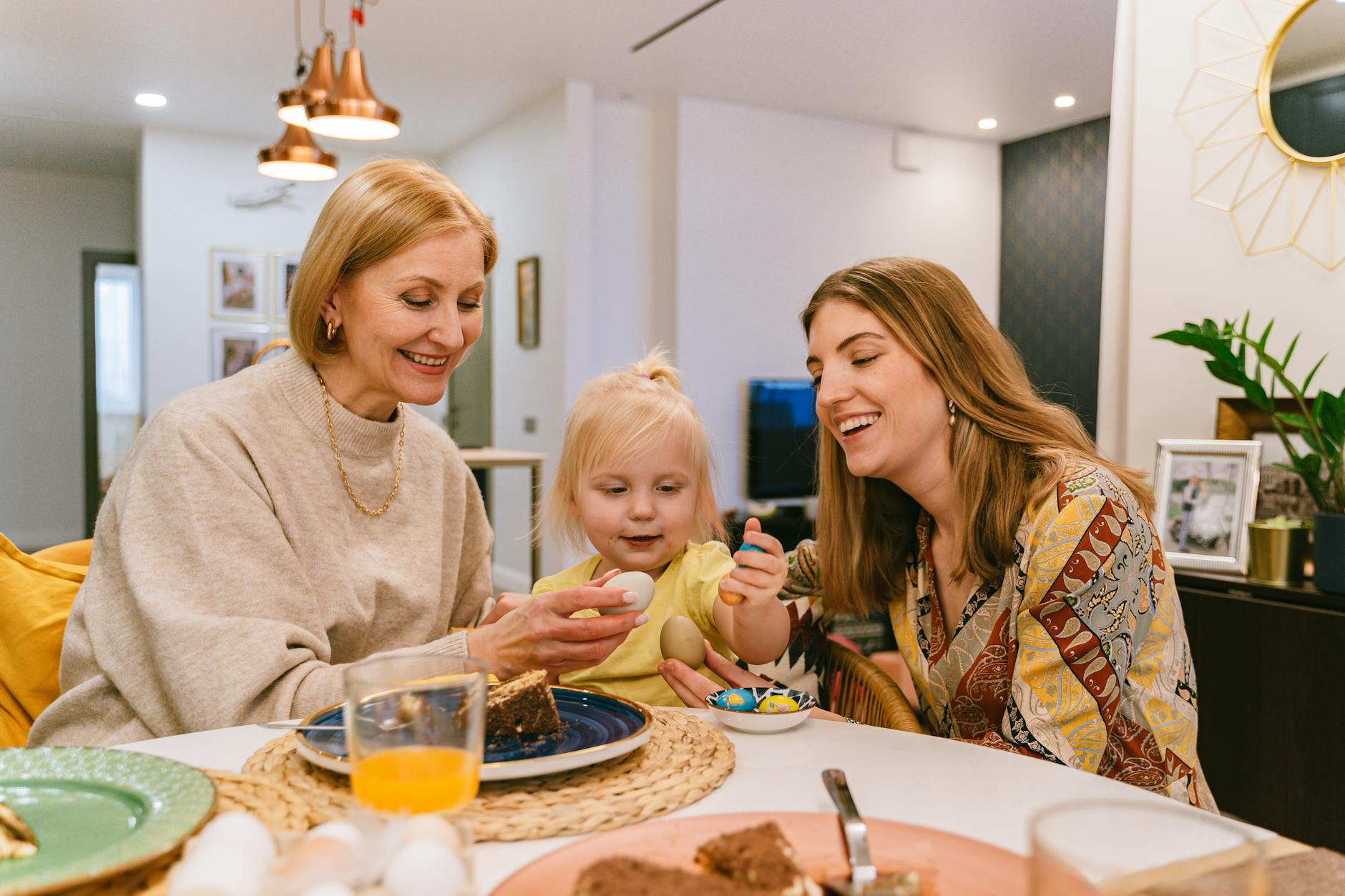 Trois générations en famille avec œufs de Pâques colorés à table